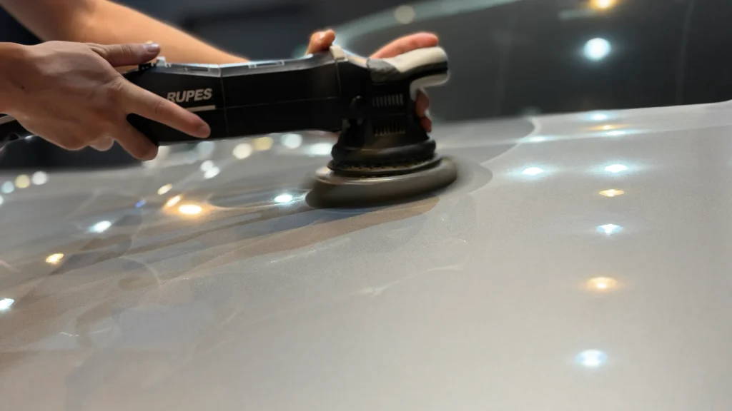 ポリッシャーでポルシェ911のボンネットパネルを研磨する施工工程