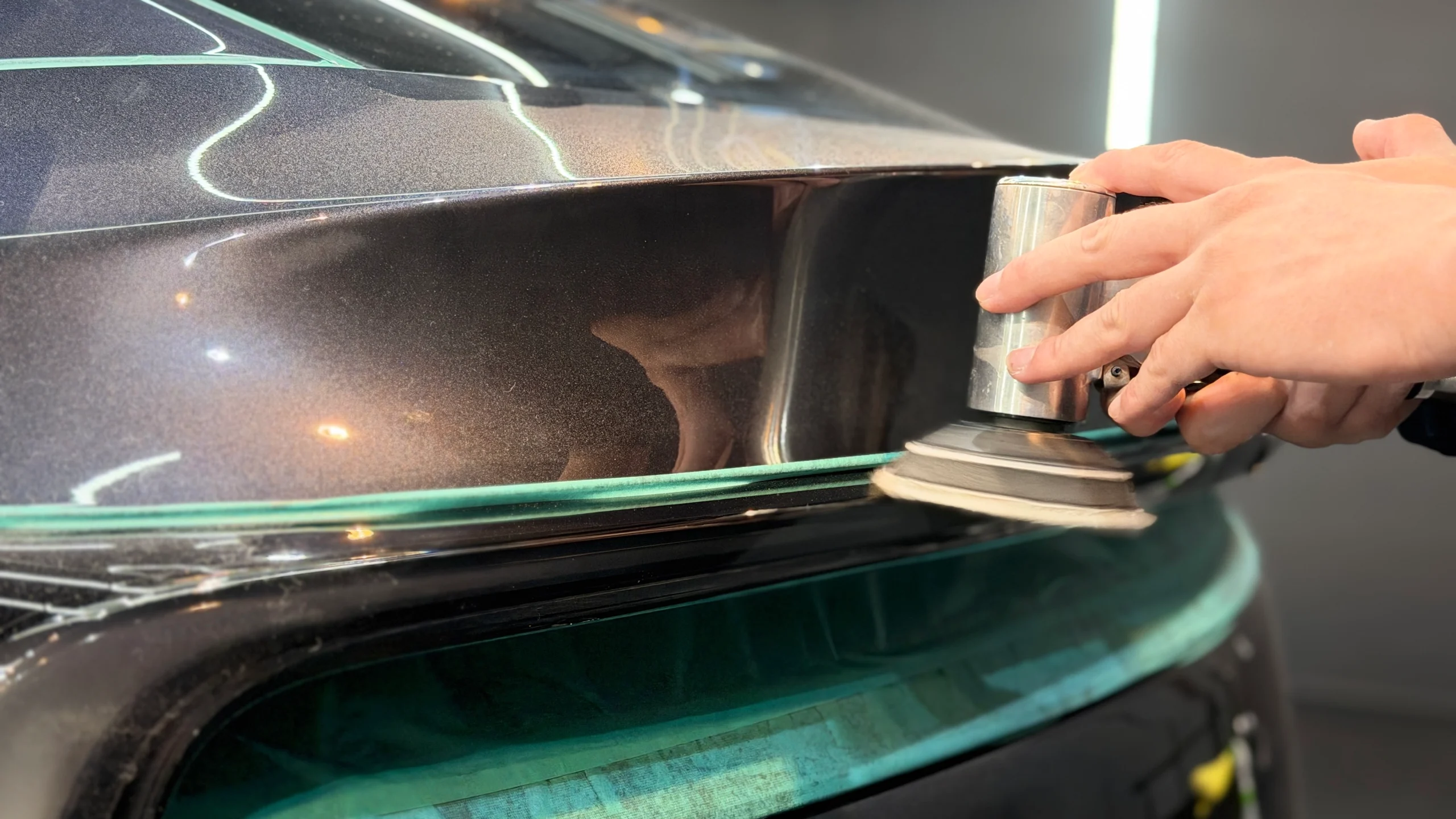 テスラ Model Y ステルスグレーの塗装面を小型ポリッシャーで研磨し、セラミックコーティング前の下地調整を行う様子