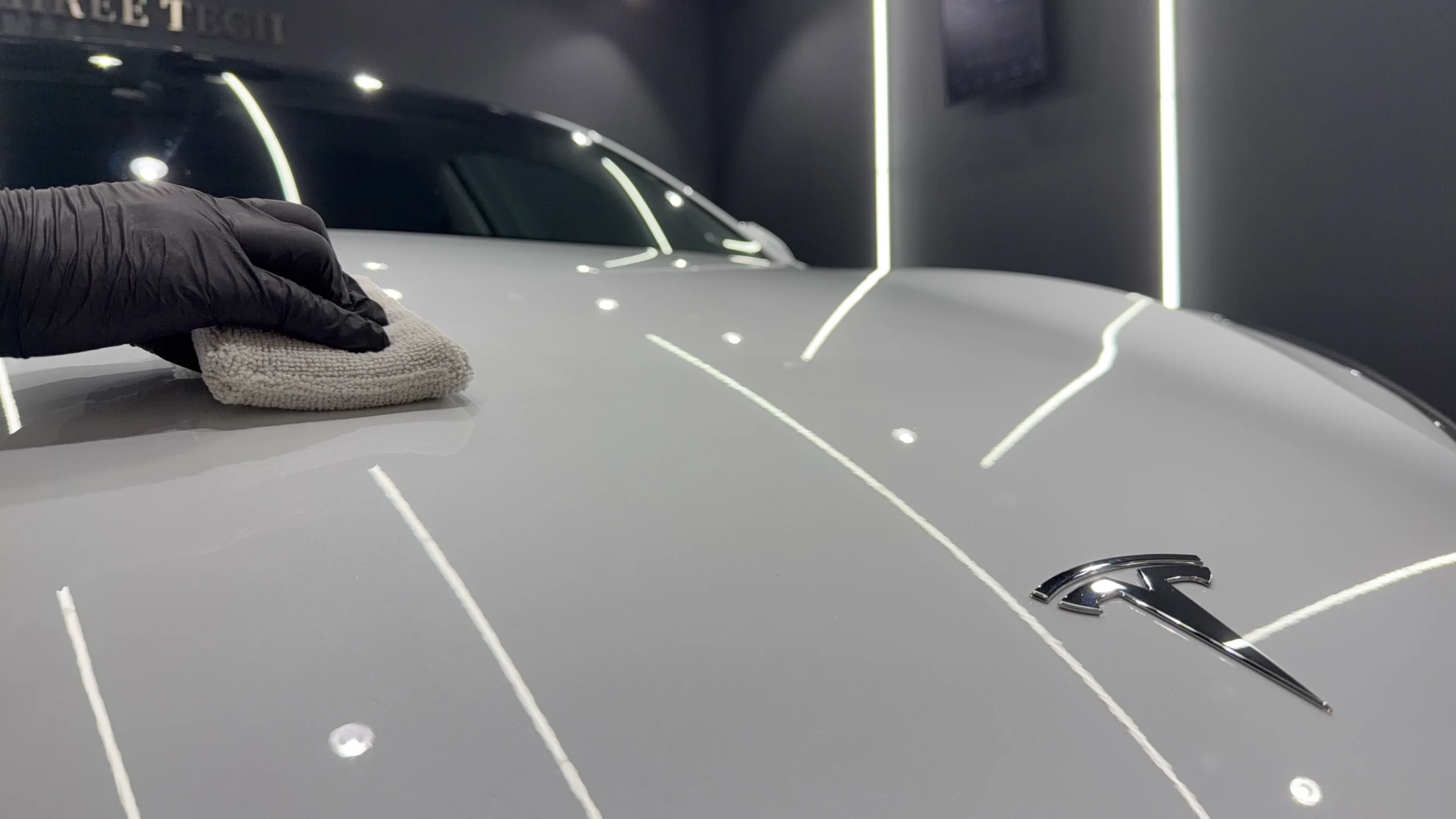 テスラ Model 3のボンネットへFEYNLAB CERAMIC ULTRA Ver.3を施工し専用クロスで仕上げている様子